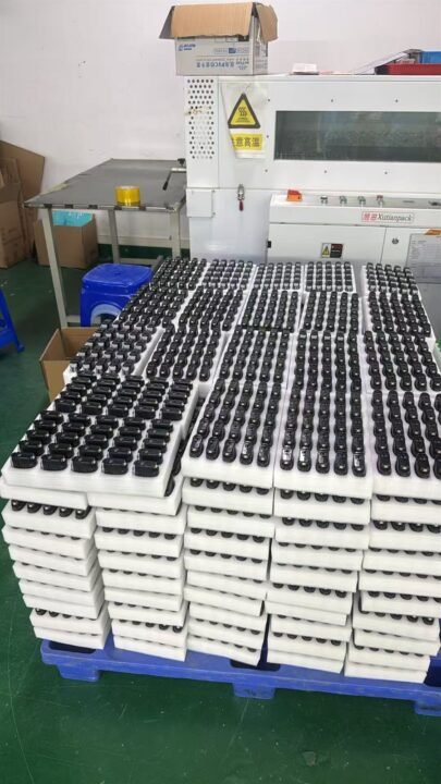 Assembled empty vape hardware staged on trays before cartoning